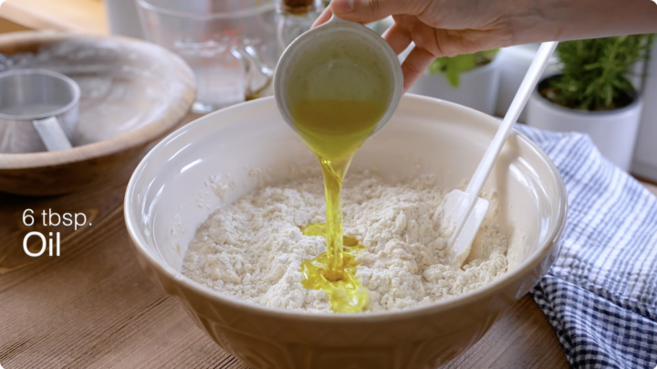 Mixing Italian bread dough together in a bowl by hand