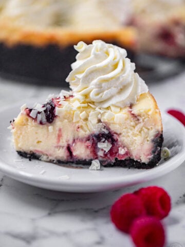 cheesecake factory white chocolate raspberry truffle cheesecake topped with white chocolate shavings and whipped cream topping