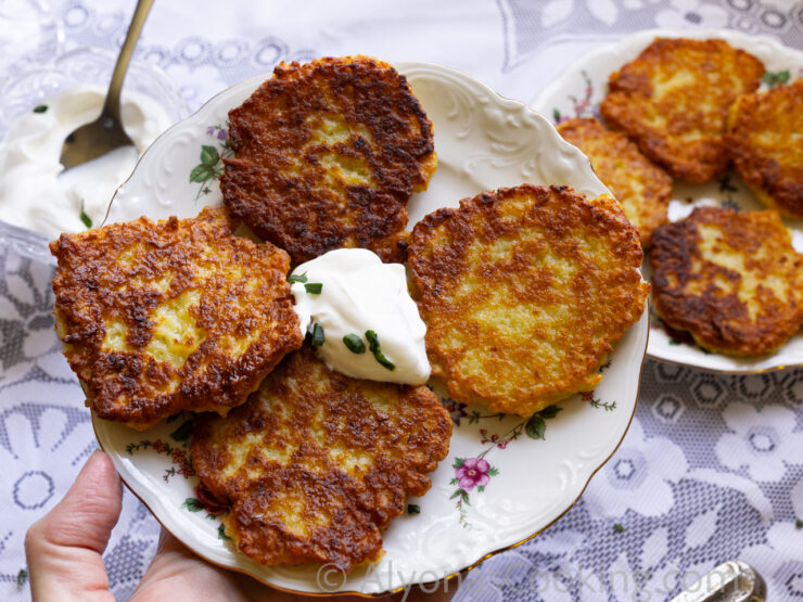 image of four Ukrainian potato pancakes on a plate with sour cream