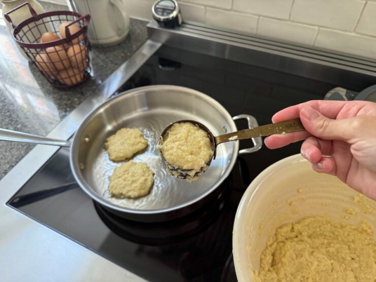 image of scooping the potato mixture into a pan to cook potato pancakes