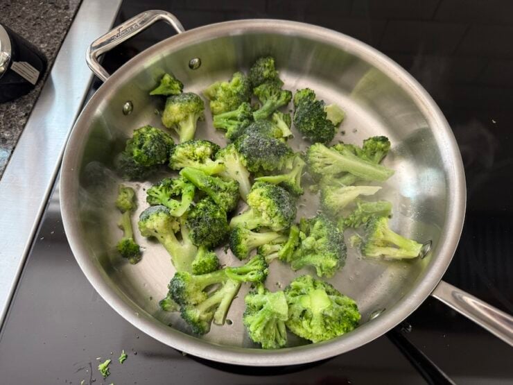 image of frozen broccoli florets being cooked in a pan
