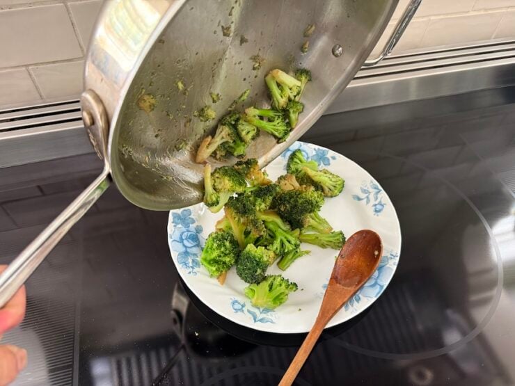 image of steamed broccoli being transferred to a flat plate