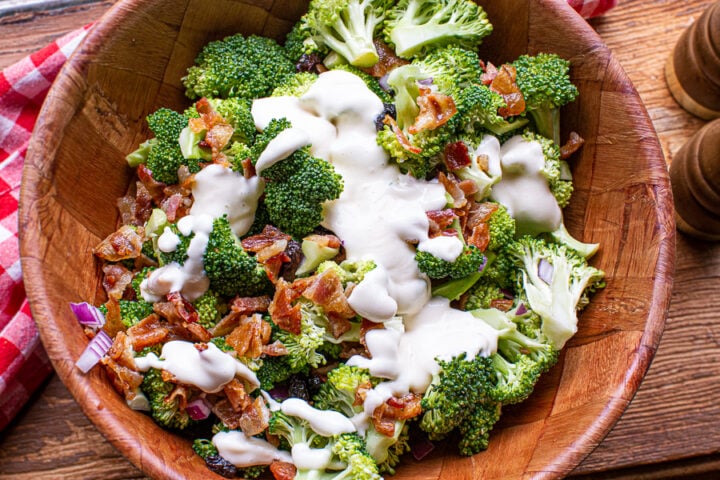 broccoli salad being tossed in homemade dressing