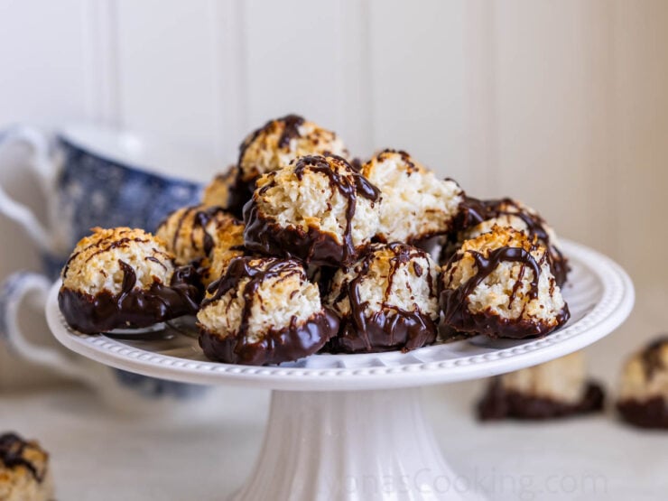 image of round coconut macaroon cookies on a cake stand dipped in chocolate