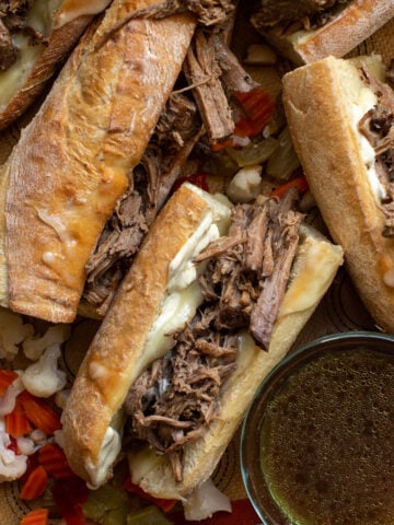 French dip sandwich in a crusty baguette roll with mustard sauce and melted Havarti cheese