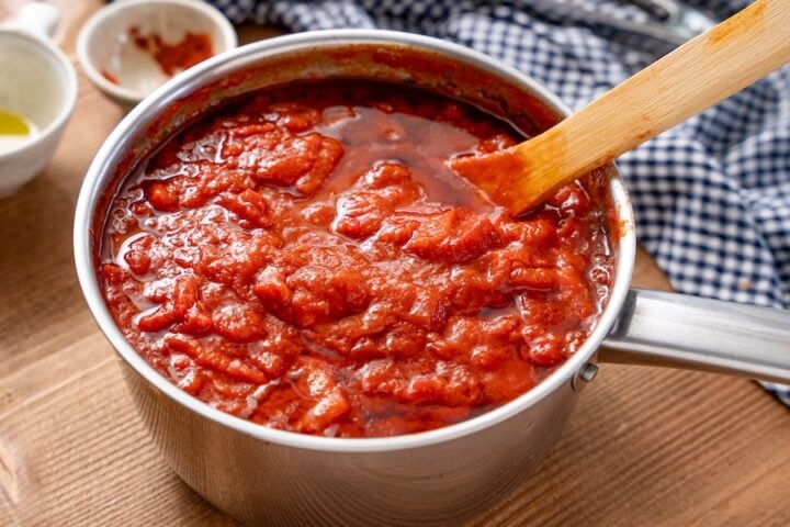 Finishing Matbucha with olive oil and paprika