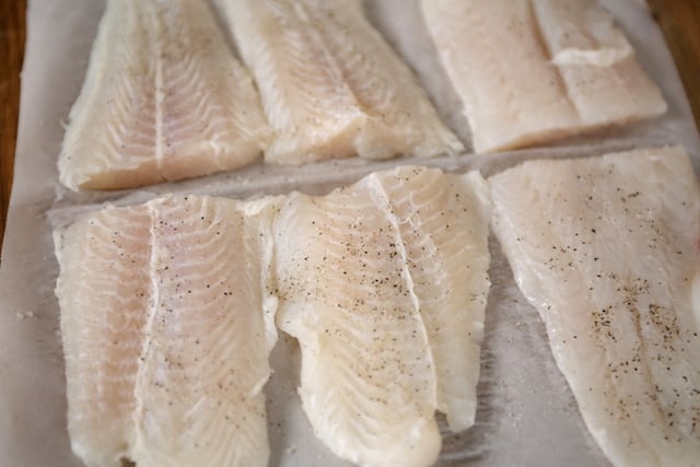 Swai fillets cut and seasoned with salt and pepper.