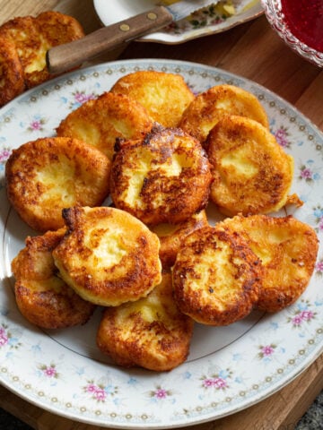 Russian Syrniki recipe with farmers cheese (cottage cheese), eggs, flour, sugar, and salt.