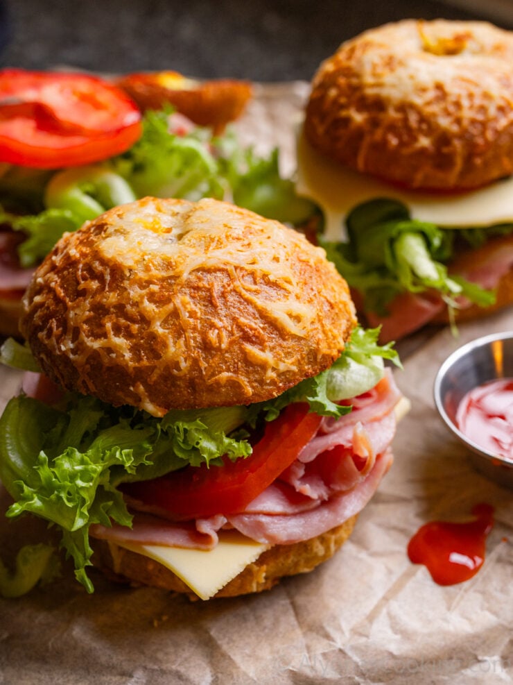 asiago bagel sandwich photographed with hot sauce