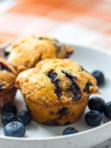 easy blueberry muffins recipe with fresh blueberries on a plate