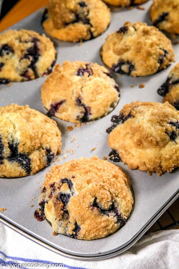 baked blueberry muffins with a cinnamon sugar topping inside a muffin pan