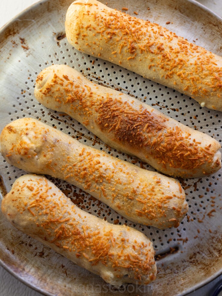 image of four homemade Costco chicken bakes on a pizza pan with holes for extra crispy bottoms