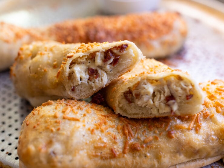 image of a sliced homemade Costco Chicken Bake stuffed with creamy Caesar Dressing, bacon, cheese, and cooked chicken. 