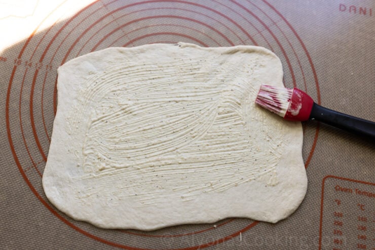 image of Costco Chicken Bake dough that is rolled out thin and brushed with Caesars dressing