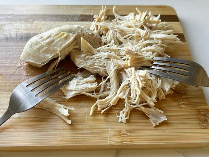 shredded chicken with two forks for white chicken chili