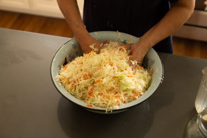 mixing cabbage with salt and carrots