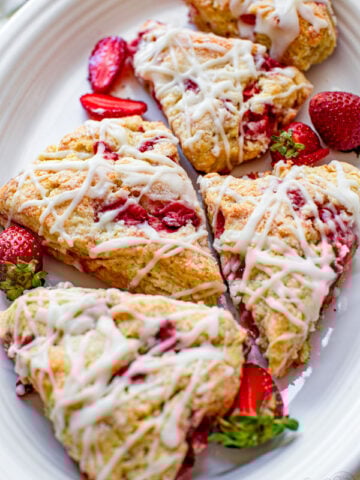 strawberry scones with a cream glaze and fresh strawberries that have a cream cheese batter