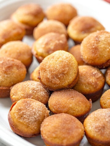 applesauce muffins with a sugar cinnamon topping on a white oval plate
