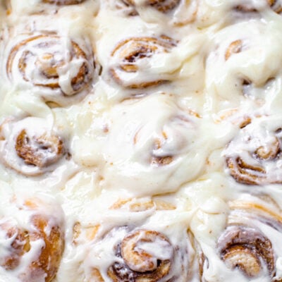cinnamon rolls like cinnabons copycat in a white baking dish with a cream cheese frosting