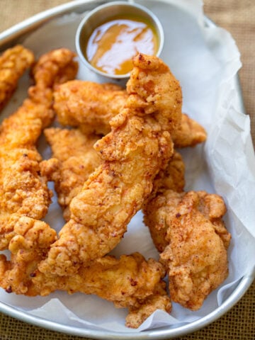 crispy chicken tenders with a golden BBQ mustard sauce as a dipping sauce