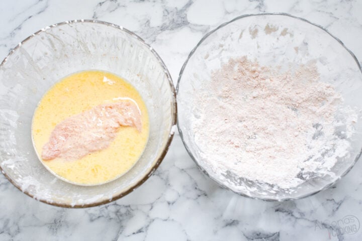 dry homemade breading for fried chicken and a bowl of wet batter for fried chicken strips being dredged and dipped in both before frying