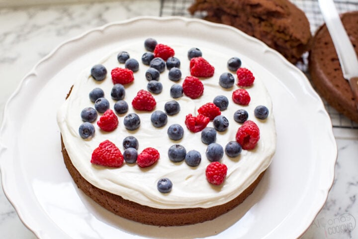 german chocolate cake covered in a cream cheese frosting and berries