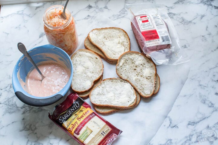 how to make a reuben sandwich with pastrami, swiss cheese, homemade sauerkraut, thousand island dressing over rye bread