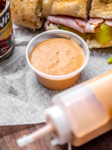 subways southwest chipotle sauce in a container and squeezable bottle by a sandwich