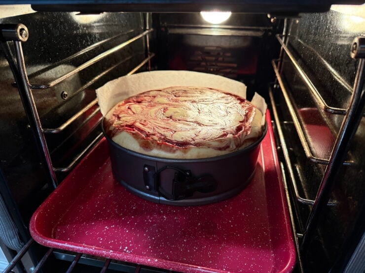 image of a baked white chocolate raspberry cheesecake in a commercial oven