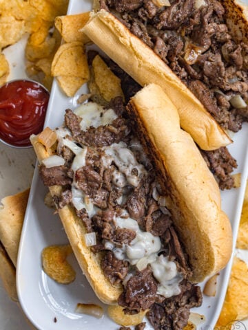 image of Philly cheesesteaks on a plate made from sliced beef, provolone cheese, and fried onions
