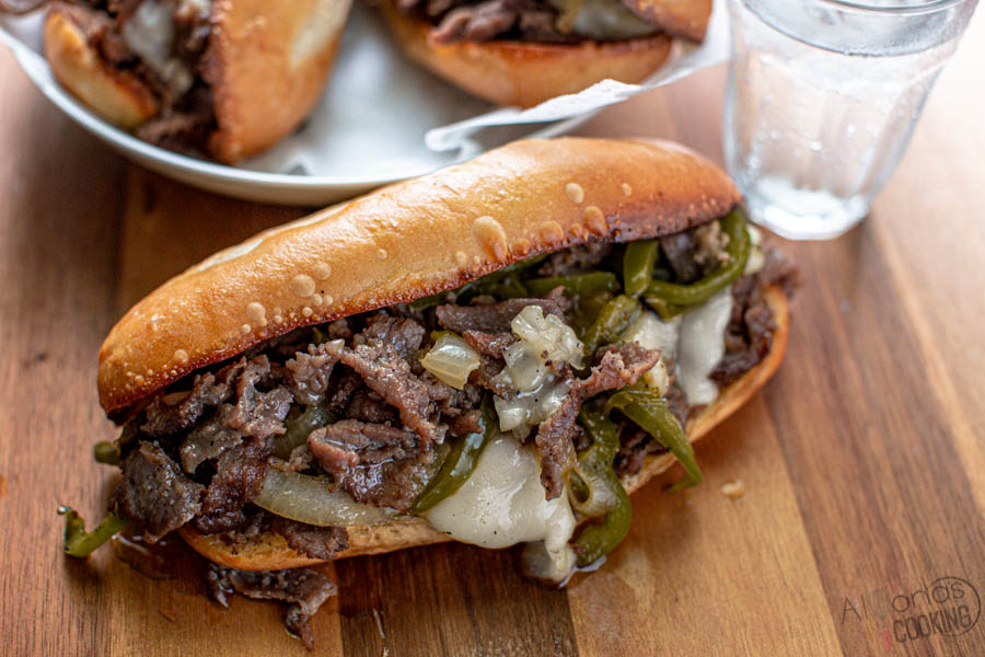 This Philly Cheesesteak Sandwich is made with marinated chuck roast shavings, caramelized onions, and peppers then broiled over toasted hoagie rolls with provolone cheese! It's one of the softest steak slices you'll have in a Philly Cheesesteak! Philly Cheesesteak Recipe How-to . #Phillycheesesteak #phillycheesesteakrecipe #cheesesteak #alyonascooking #phillycheesesteaksandwich #sandwich Philly Cheesesteak Sandwich Recipe