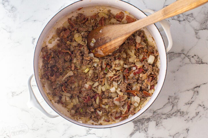how to make Zuppa Toscana in one-pot. Step 1: fry the onion, Italian sausage, bacon, and garlic first.