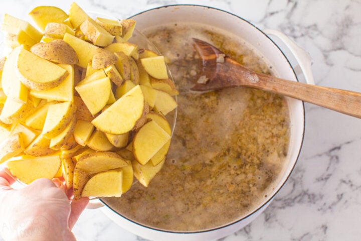 How to make Zuppa Toscana in one-pot. Step 2: Add the water, salt, chicken bouillon, and potatoes. Simmer for 25 minutes.