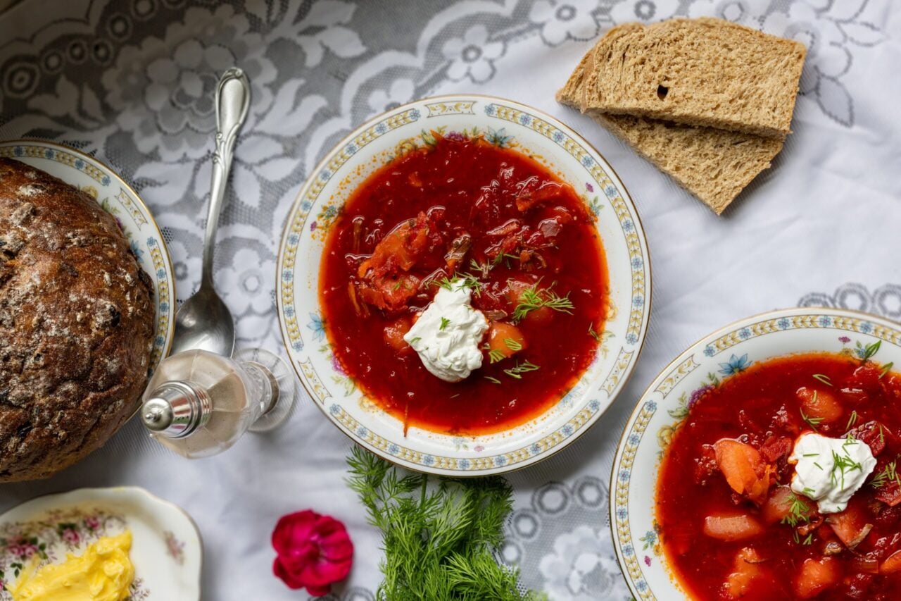 image of Classic red borscht soup in vintage bowl dolloped with sour cream