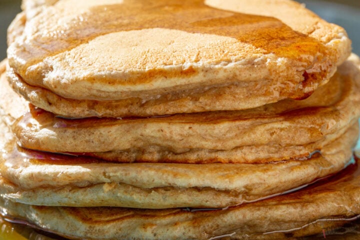 stack of whole wheat pancakes with maple syrup
