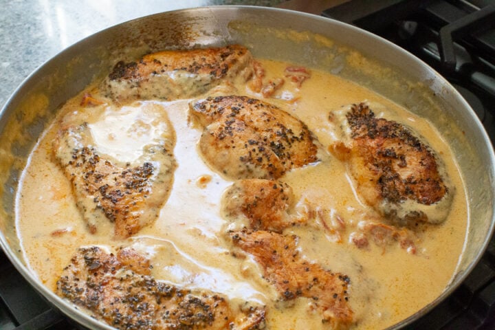 image of finishing off the chicken breast in a creamy Tuscan chicken sauce