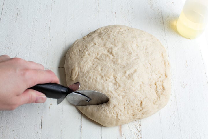 cutting pretzel dough with a pizza cutter