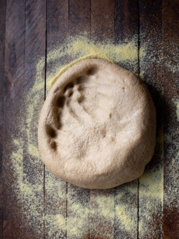whole wheat pizza dough in cornmeal
