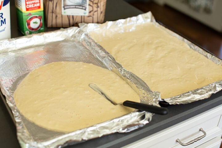 spreading honey cake batter onto jelly roll pans