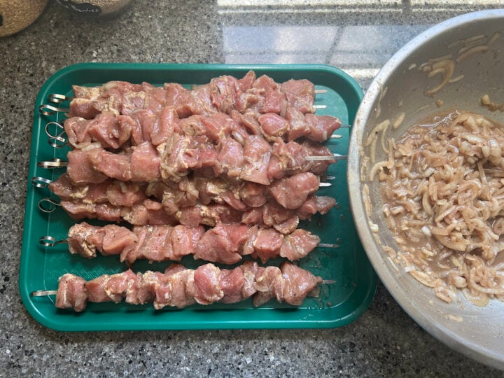 threading meat on skewers for shashlik