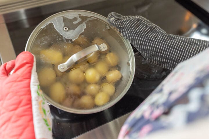 coating the boiled and steamed potatoes in melted butter and seasonings