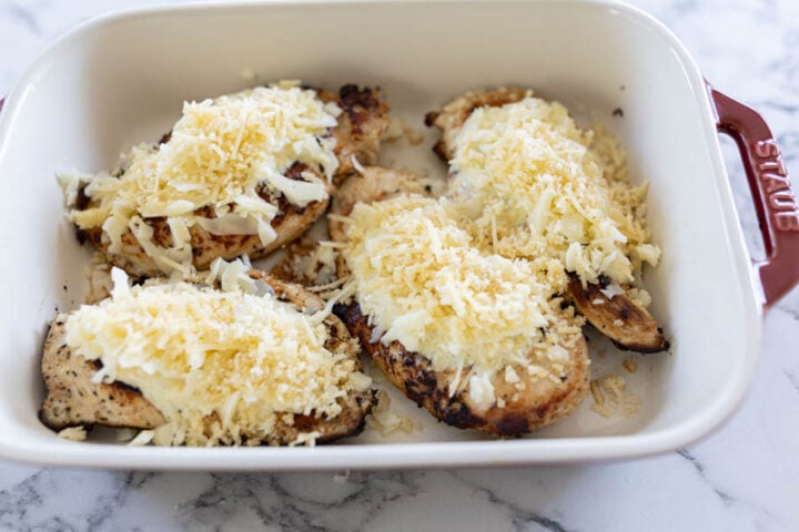 layering Longhorn parmesan crusted chicken in a casserole dish