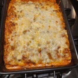 Chessy lasagna in a pan.