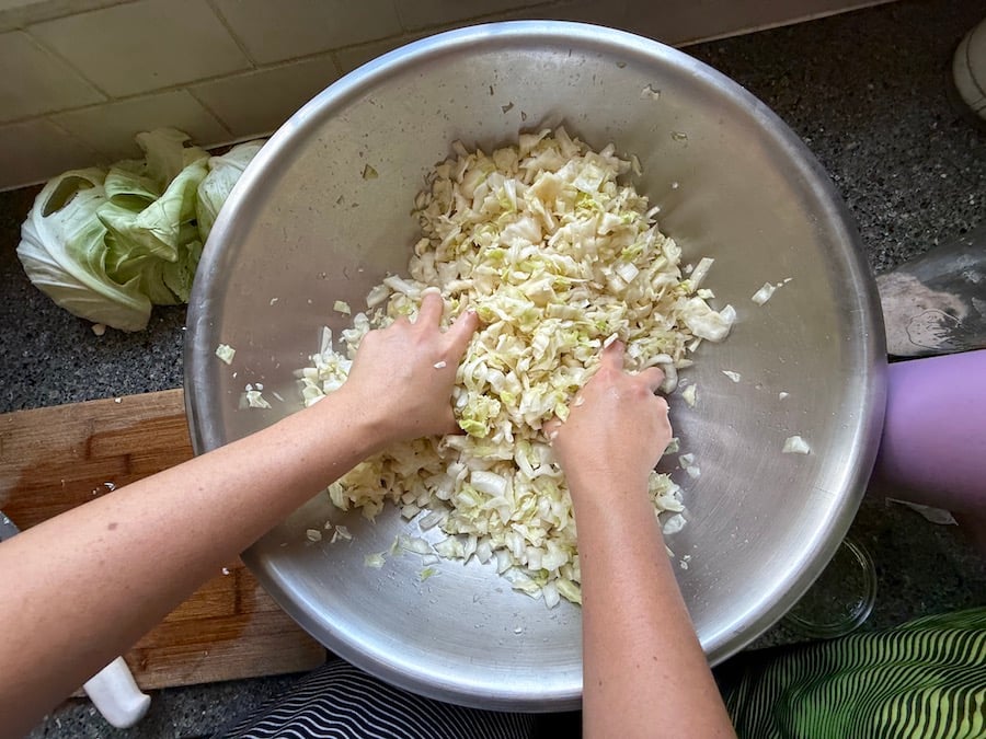 Massaging the salt into the cabbage to release its natural juices (about 15 minutes) 