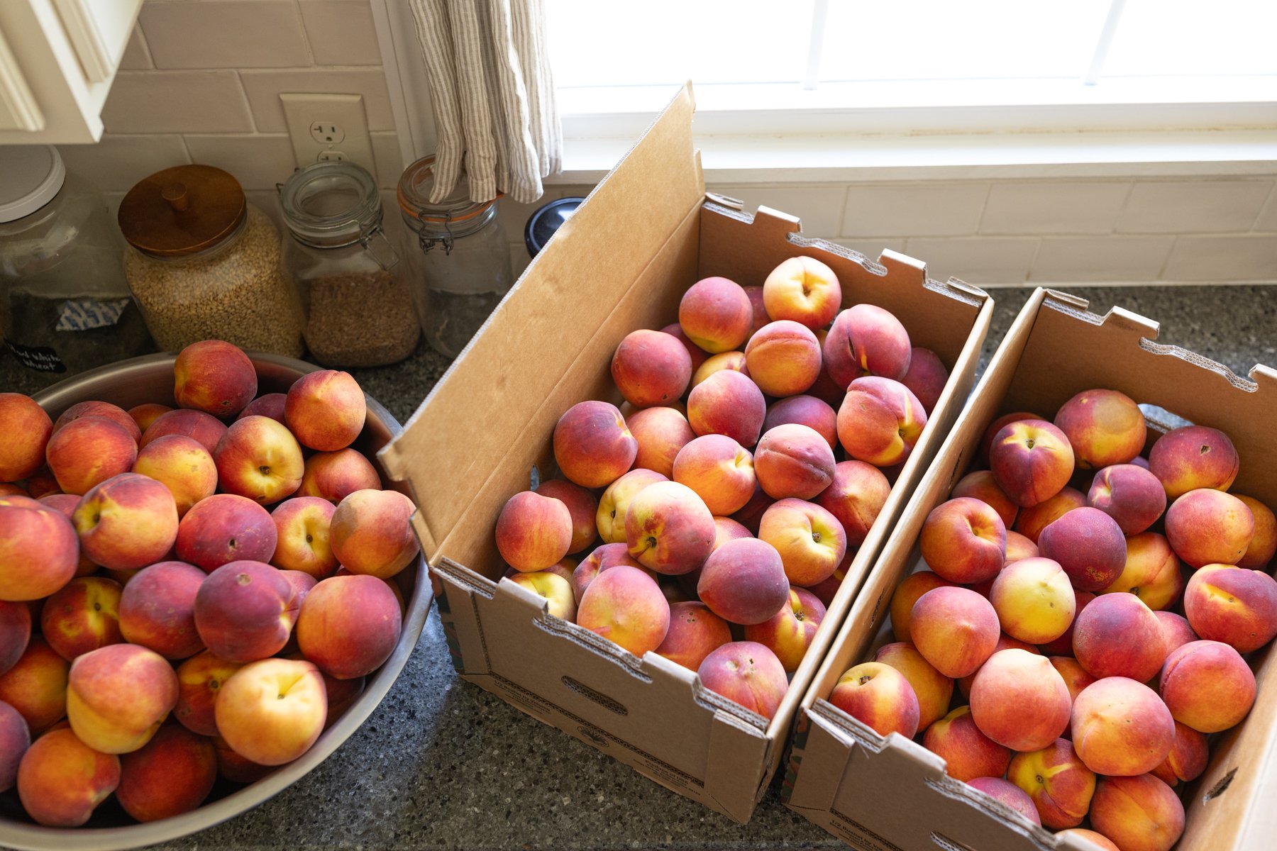 half bushels of fresh peaches ready to be canned 