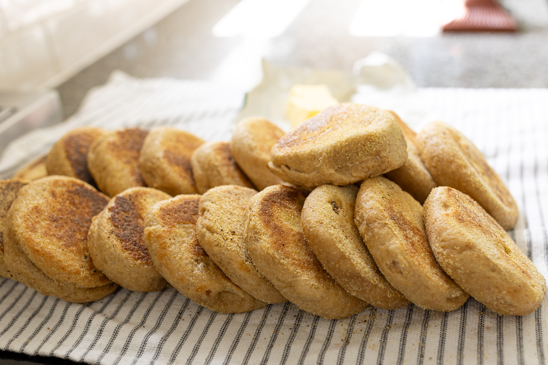 A big batch of homemade English muffins made from fresh milled flour (whole wheat)