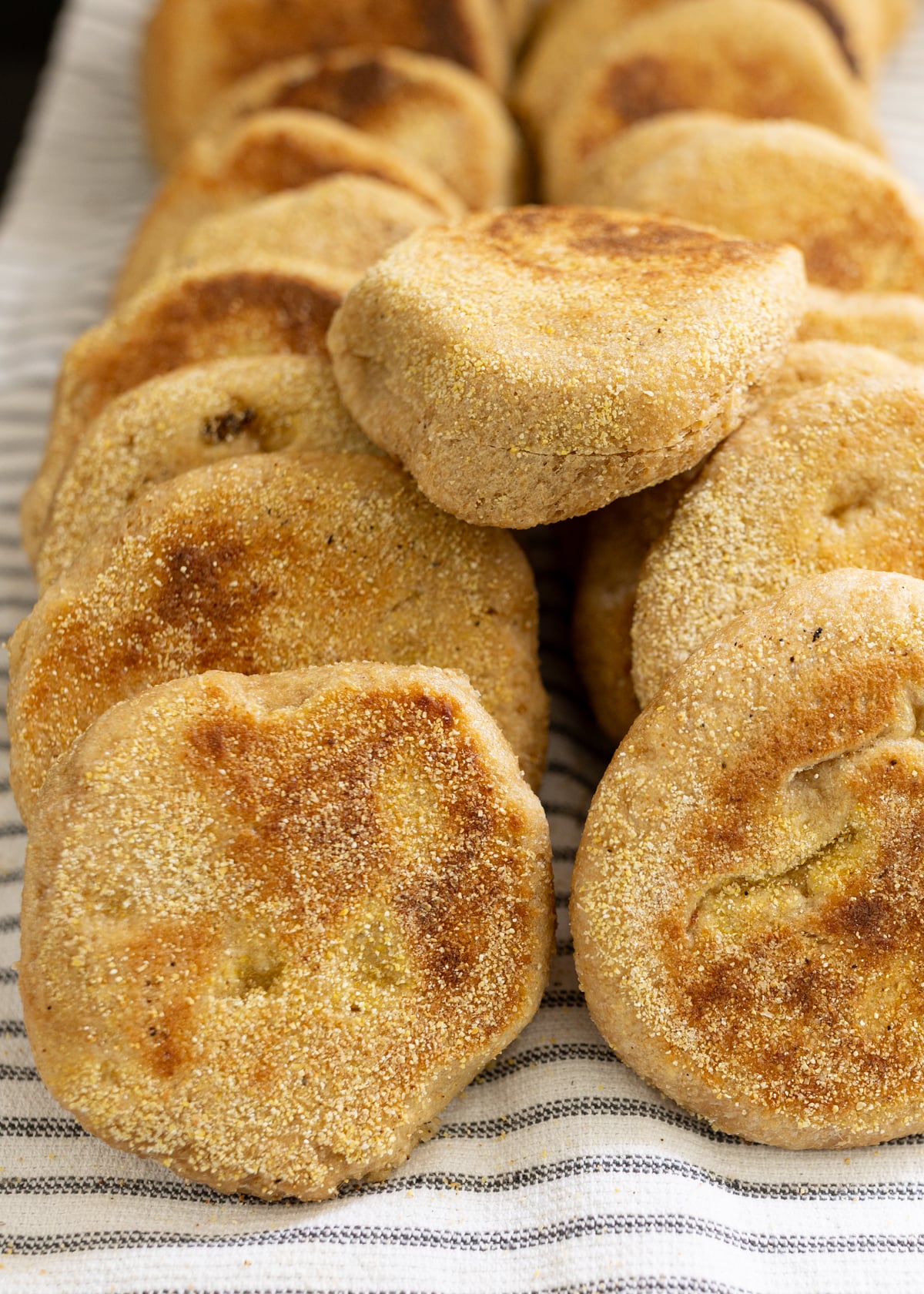 Whole wheat English muffins on a kitchen towel made from scratch