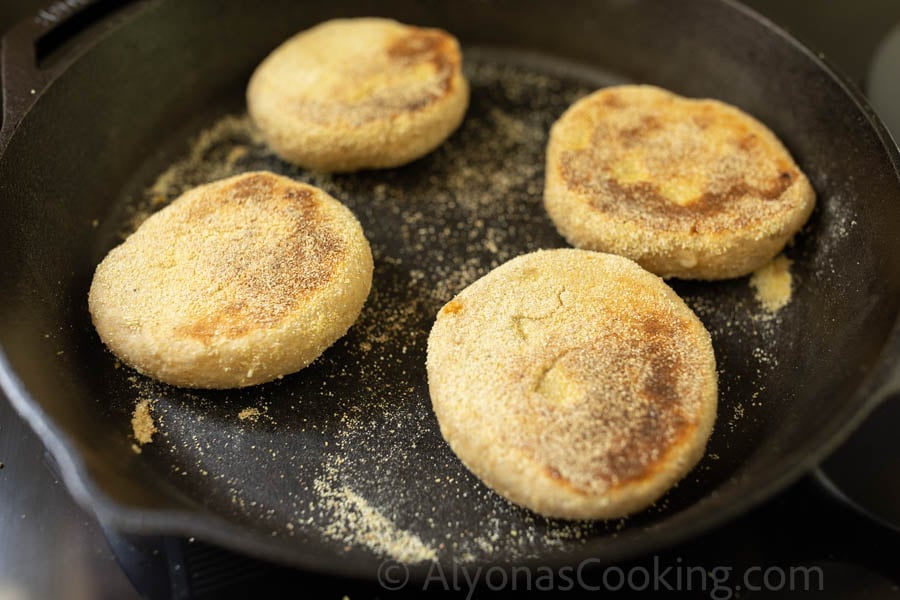 Cooked Whole wheat English muffins on a cast-iron skillet