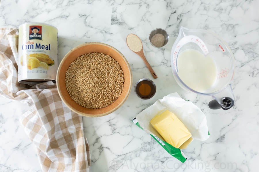 All ingredients for Whole wheat English muffins (kefir, butter, dry active yeast, honey, salt, wheat berries, cornmeal).