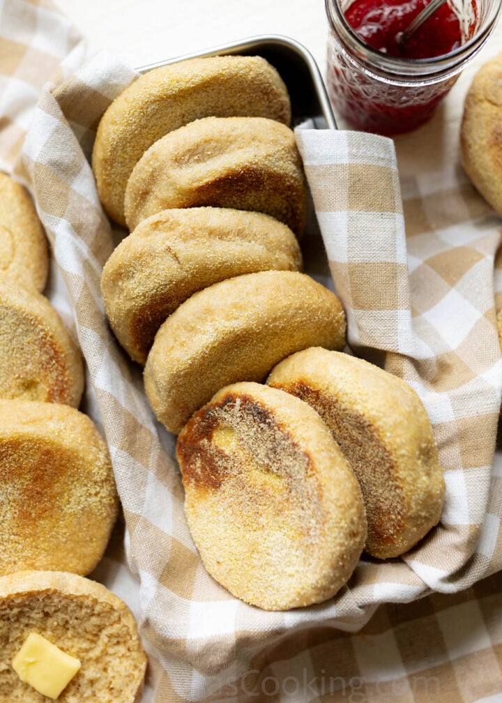 Whole Wheat English muffins arranged on a farmhouse kitchen towel in a bread pan